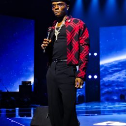 Wizkid on stage holding a microphone at Canex in Algiers, 2025