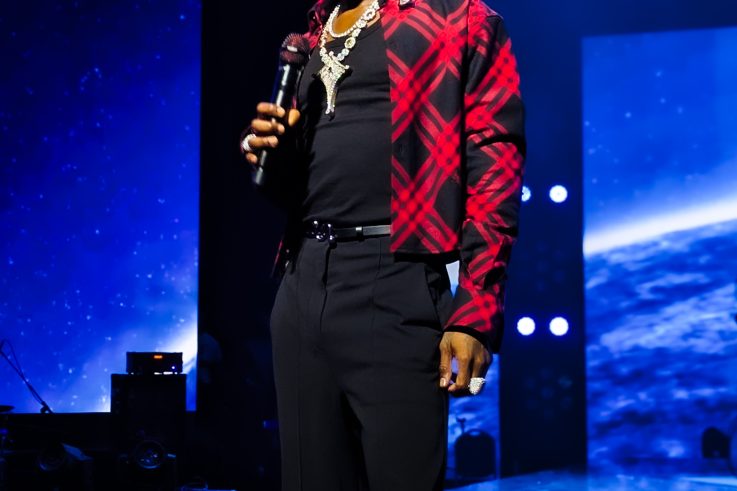 Wizkid on stage holding a microphone at Canex in Algiers, 2025