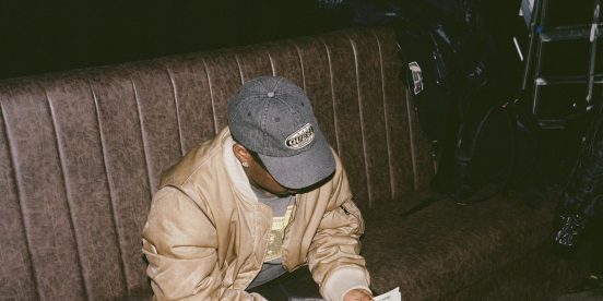 Asake counting cash in a Guess cap during the M$NEY era