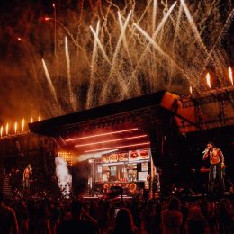 Burna Boy performing live on stage with fireworks and crowd