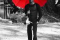 Fireboy DML holding a red umbrella in a black-and-white ZUKO! promo