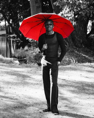 Fireboy DML holding a red umbrella in a black-and-white ZUKO! promo