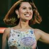RAYE performing in a floral dress on stage