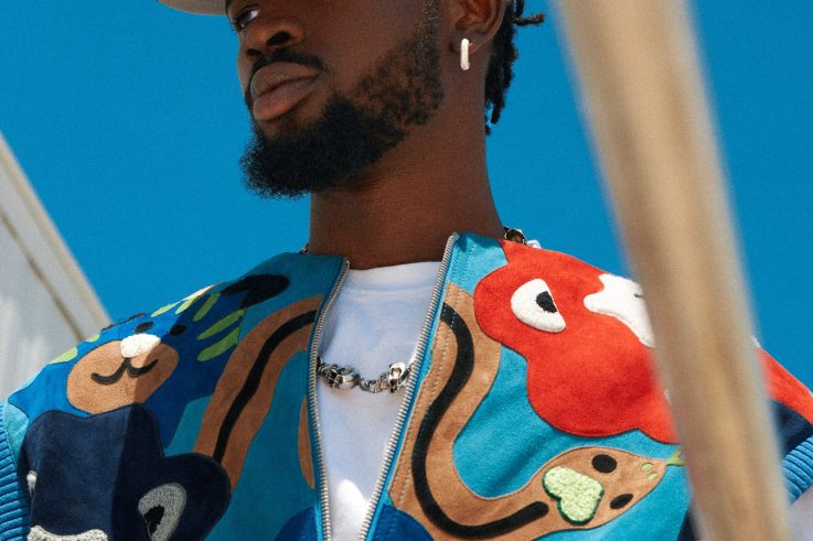 Black Sherif in a black cap and patterned jacket, photographed in Virginia