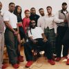 Burna Boy seated in red On sneakers with his family and team for his first On collection.