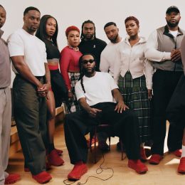 Burna Boy seated in red On sneakers with his family and team for his first On collection.