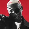Ruger in a black eye patch and leather jacket, pointing at the camera against a red background