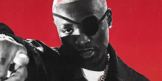 Ruger in a black eye patch and leather jacket, pointing at the camera against a red background
