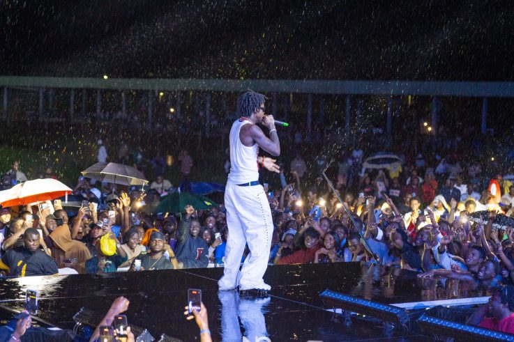 Shallipopi performing in the rain at the Oba of Benin's 10th coronation anniversary celebration in Benin City