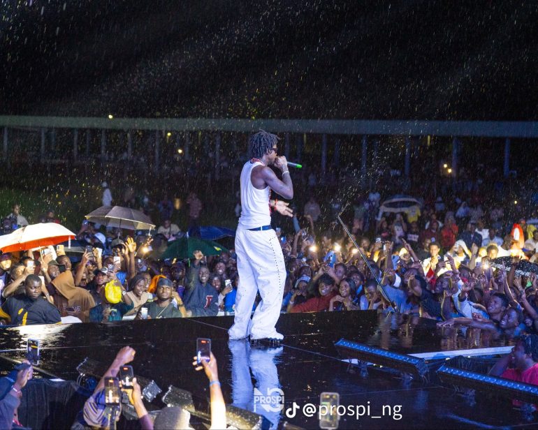 Shallipopi performing in the rain at the Oba of Benin's 10th coronation anniversary celebration in Benin City